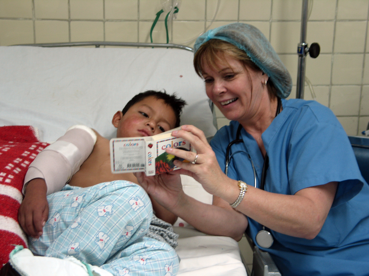 A nurse reading to a child in a hospital bed