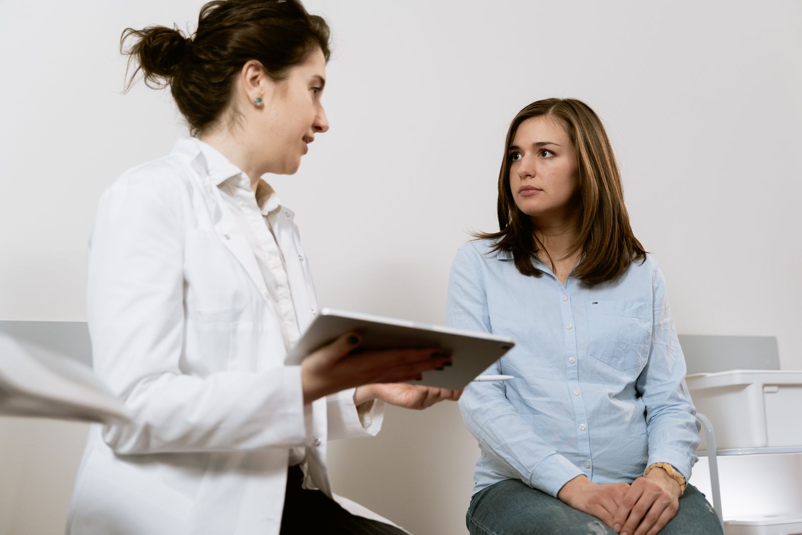 A patient and advocate talking with a clinician in a supportive healthcare setting